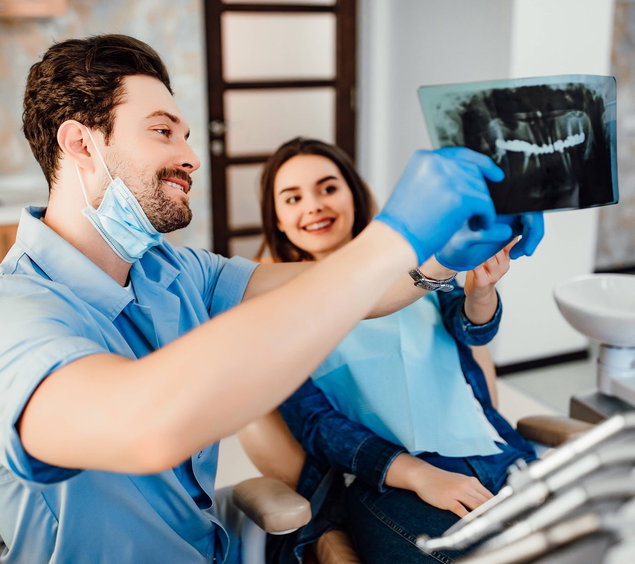 Dentist reviewing X-ray results with smiling patient